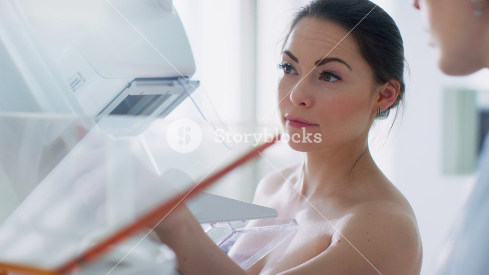 In the Hospital, Back View Shot of Female Patient Undergoing Mammogram Screening Procedure. Healthy Young Female Does Cancer Preventive Mammography Scan. Modern Hospital with High Tech Machines.