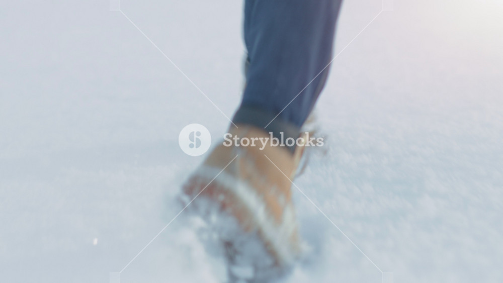 Following Footage of a Woman Walking on a Snow. Focus on Legs. Beautiful White Winter Weather with Fresh Snowfall. Woman Leaves Footprints in the Snow.