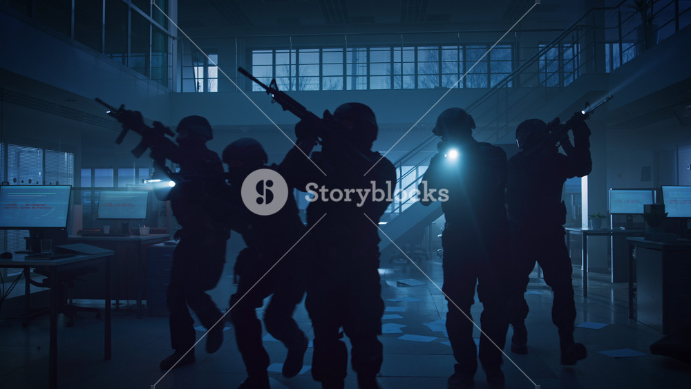 Masked Squad of Armed SWAT Police Officers Storm a Dark Seized Office Building with Desks and Computers. Soldiers with Rifles and Flashlights Move Forwards and Cover Surroundings.