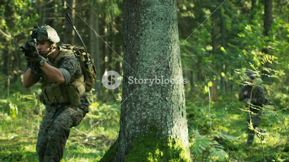 Squad of Five Fully Equipped Soldiers in Camouflage on a Reconnaissance Military Mission, Running from Behind the Cover. They're Moving in Formation Through Dense Forest. Shot in Slow Motion.