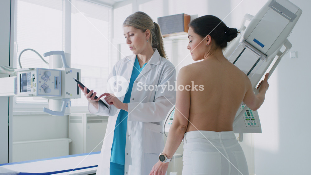 In the Hospital, Female Patient Listens to Mammography Technologist / Doctor Uses Tablet Computer, Explains Importance of Breast Cancer Prevention. Mammography Procedure.