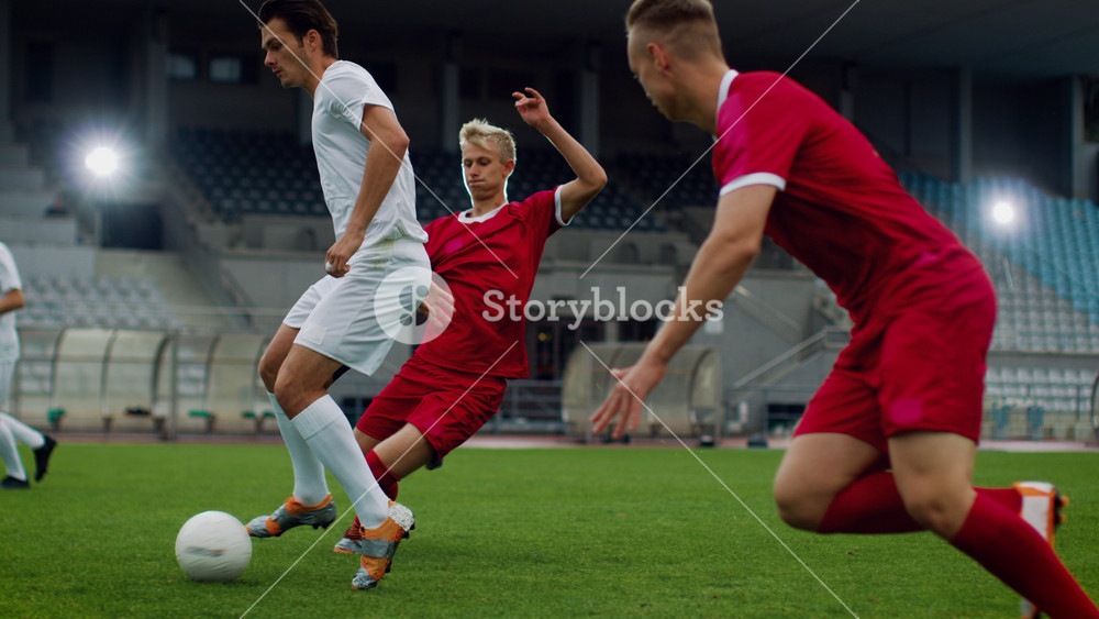 Focus on Legs of a Professional Soccer Player Leading with a Ball, Masterfully Dribbling Around His Opponents. Two Professional Football Teams Playing on Stadium. Energetic Play.