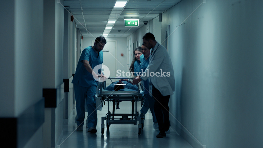 Emergency Department: Doctors, Nurses and Paramedics Run and Push Gurney / Stretcher with Seriously Injured Patient towards the Operating Room. Bright Modern Hospital with Professional Staff Saving Lives.
