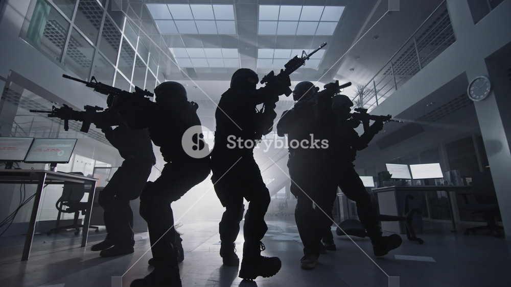 Masked Squad of Armed SWAT Police Officers Slowly Move in a Hall of a Dark Seized Office Building with Desks and Computers. Soldiers with Rifles and Flashlights Surveil and Cover Surroundings.