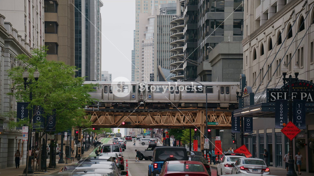Chicago L Train moving above urban street traffic in downtown Cook County Illinois, iconic modern skyscrapers and pedestrians walking along