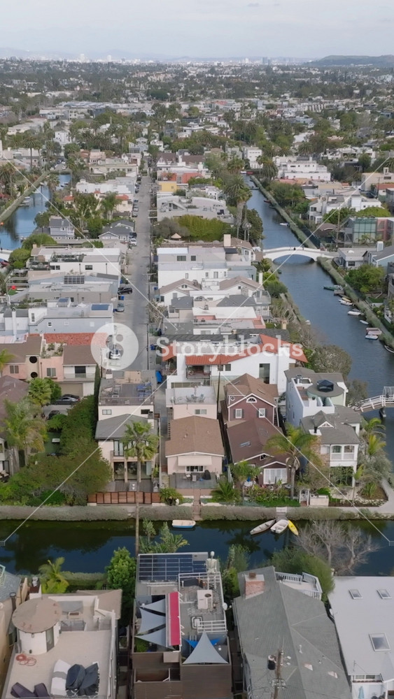 Aerial slider of Venice Canals surrounded by dense town development. Residential suburb of metropolis. Los Angeles, California, USA