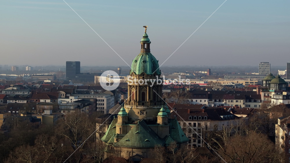 Aerial shot slowly orbiting out from majestic dome of the Christuskirche, revealing surrounding cityscape of Mannheim, Germany