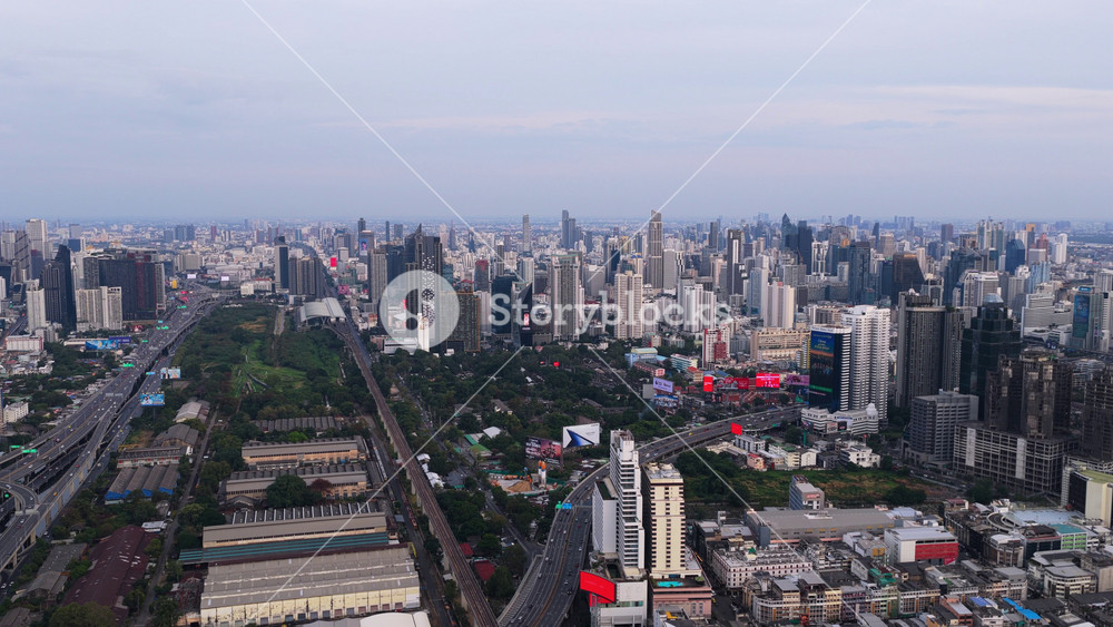 Tripod aerial perspective showing sprawling cityscape of Bangkok, Thailand capital. Modern skyscrapers and urban traffic moving on highways