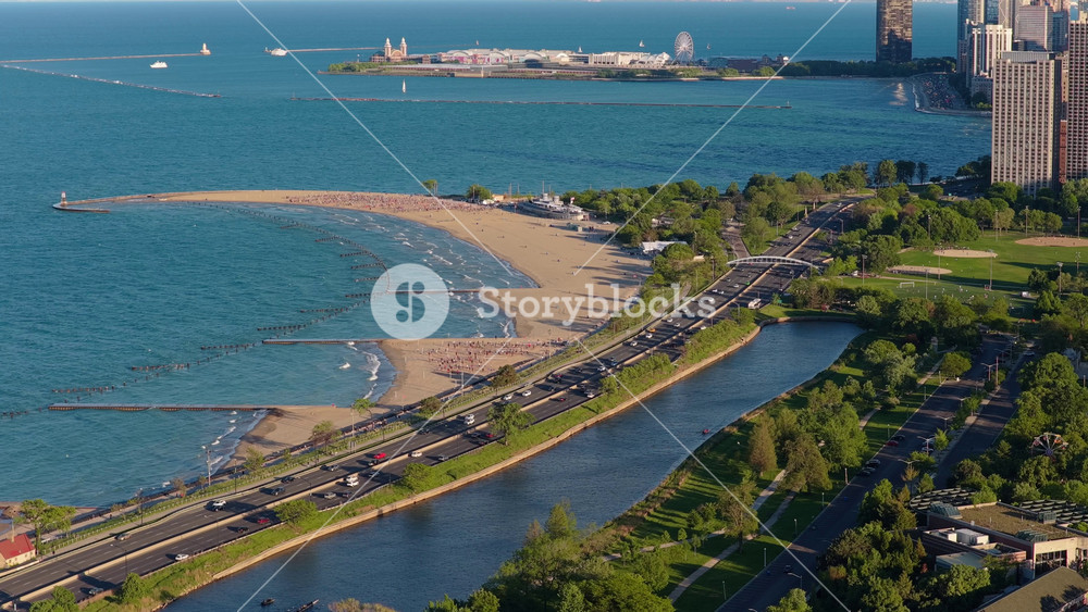 Aerial tripod view of North Avenue Beach in Chicago, Illinois with car traffic flowing on Lake Drive and Navy Pier background on a sunny