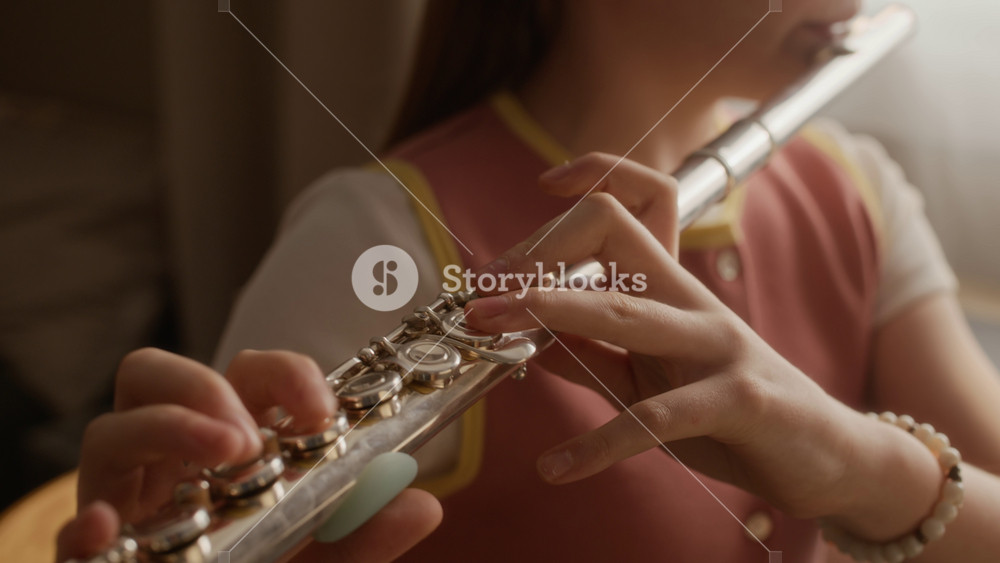 Cropped shot of child playing flute during music lesson at home, pressing keys with fingers. Footage ideal for promotional materials of music schools or online tutoring platforms