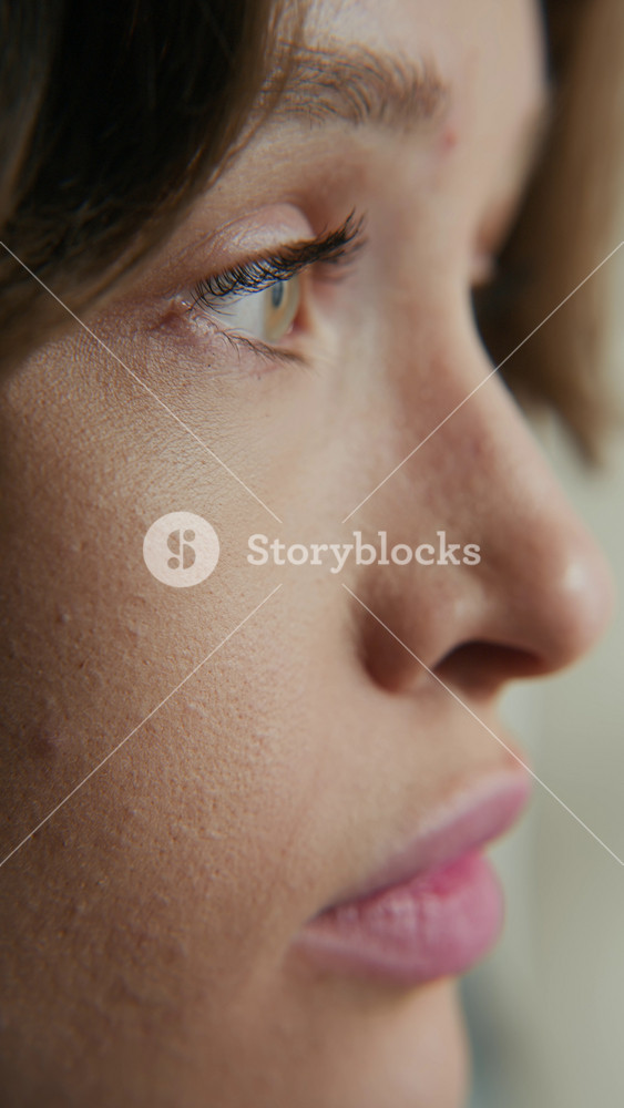 Vertical big close up shot of face of gen Z Caucasian woman with real skin texture narrowing eyes, feeling drowsy indoors