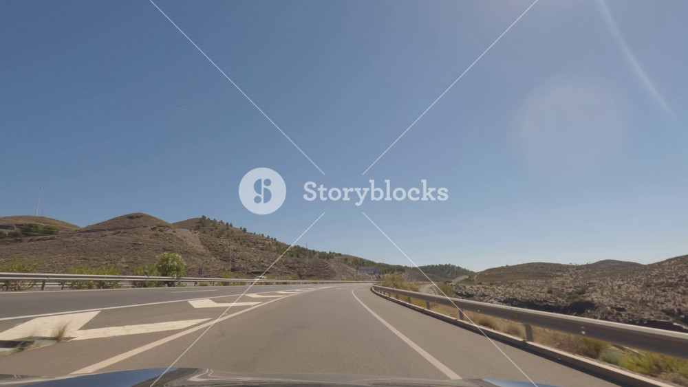 First person view, FPV, from dashcam of car driving mountain road from Calar Alto Observatory to Tabernas Desert in Almeria, Andalusia, Spain, Europe. Road trip in POV,