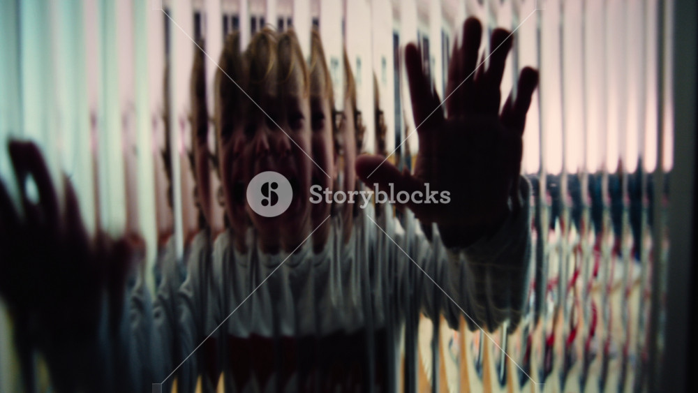 Crying toddler reaching outward with both hands against textured glass suggesting childhood trauma emotional abandonment depression fear and a powerful sense of isolation and despair