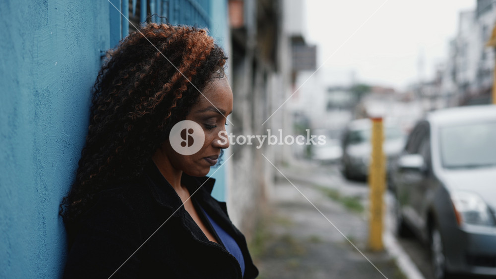One Pensive hispanic Black Woman in 50s Facing Life's Challenges standing in urban street in South America. Person in quiet despair feeling hopeless