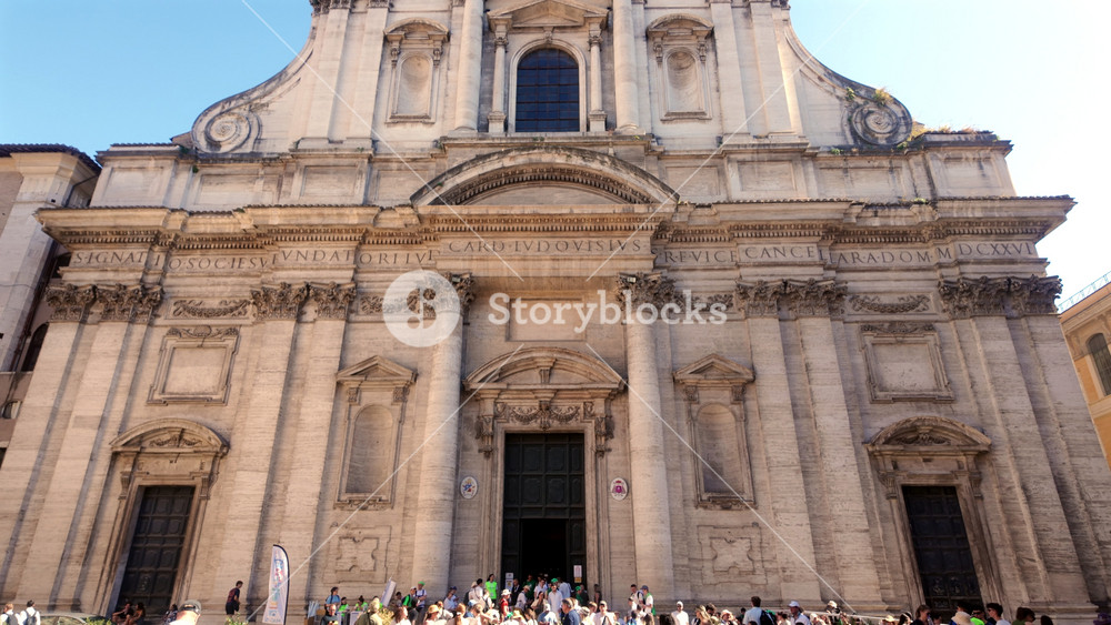 Rome Italy July 30th 2025 Exterior Facade Of Church Of The Gesu In Rome With Tourists Gathering At Entrance Under Classical Baroque Architecture And Latin Inscription