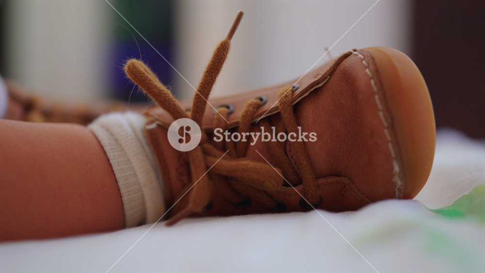 Close detail toddler shoe resting on bed during sleep, childhood footwear moment suggesting rest after play and peaceful quiet family home environment