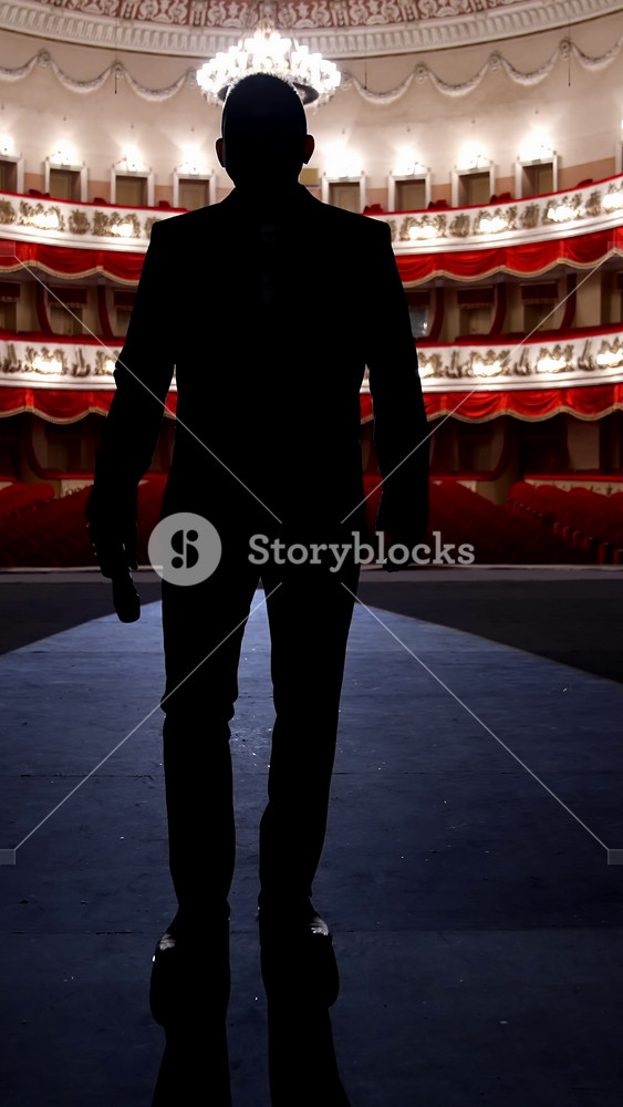 Actor walks on a scene in front of empty auditorium. Financial losses of organizers in entertainment sector because of quarantine. Vertical video