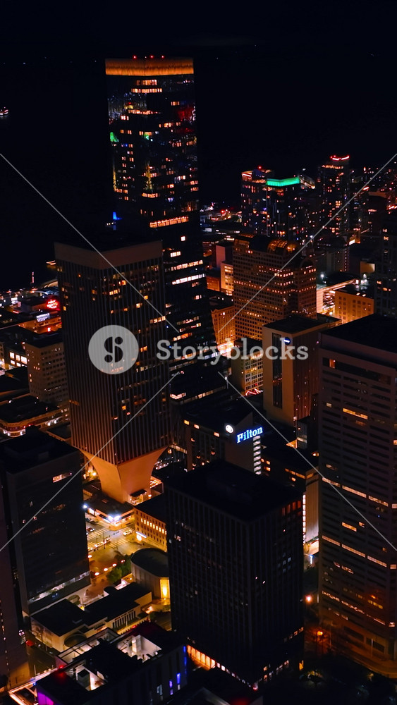 Beautiful buildings with lights in windows in the downtown of Seattle, Washington State, the USA. Drone footage above the city at night. Vertical video