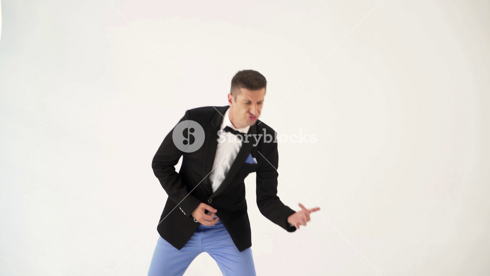 a man in a black jacket is behaving like a guitar player at a concert of his rock band. Parody of the musician in the studio