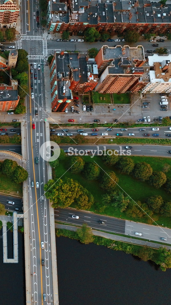 Quick and busy traffic on the highways built near the Charles River in Boston. Lots of cars moving both sides of the roads. Top view.. Vertical video