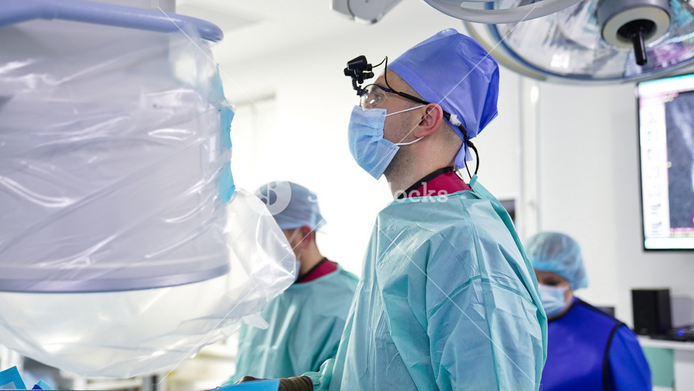 Kyiv, Ukraine, 5 May 2022: Portrait of a surgeon performing operation. Doctor looks straight in front of him. Team of medics helping the patient.