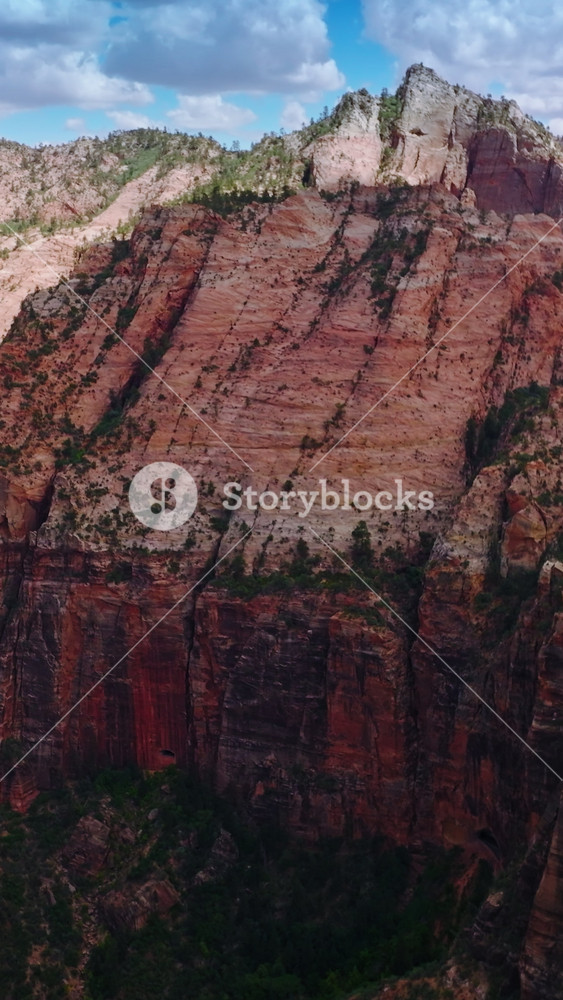 Stunning huge rocks of diverse colors and shades. Canyons of Zion National Park in Utah, USA at backdrop of blue sky with clouds. Vertical video