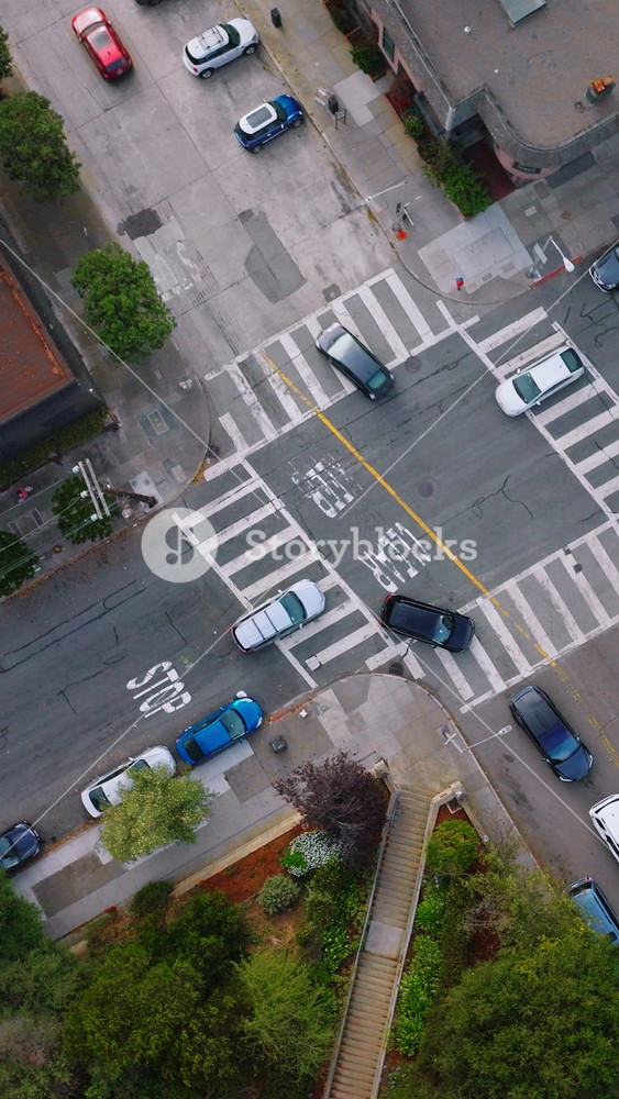 Usual crossroads crossed by private cars in urban city. Top view of the street in San Francisco at daytime. Vertical video