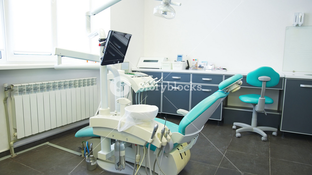 Kyiv, Ukraine, 2 May 2025: Light big cabinet of modern doctor of dentistry. Dentist's chair in the middle of the room with lamp over and attached screen.