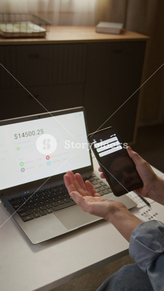Vertical close-up of hands of anonymous female cyber fraud victim holding smartphone with bank alerts, watching money disappear from bank account, stolen by scammers, clenching and shaking fists