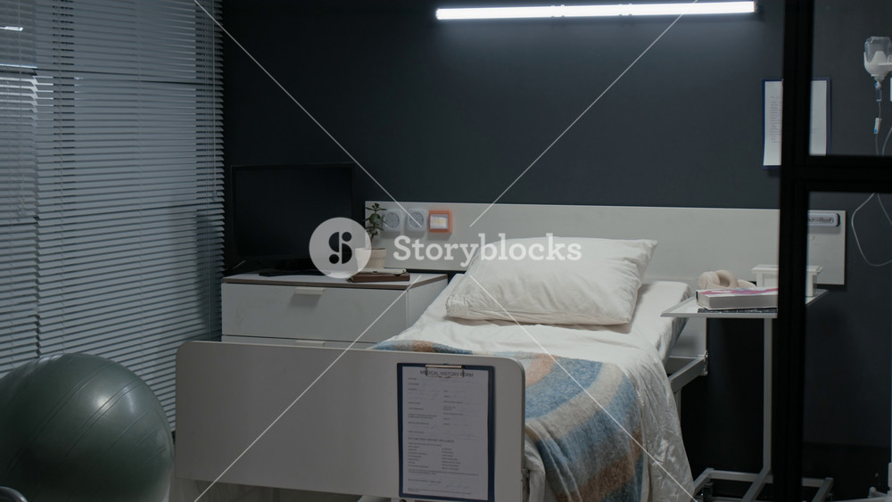 Empty hospital bed in modern maternity ward showing birthing ball,IV stand,and clipboard. Clip is suitable for healthcare marketing,medical documentaries,or insurance commercials