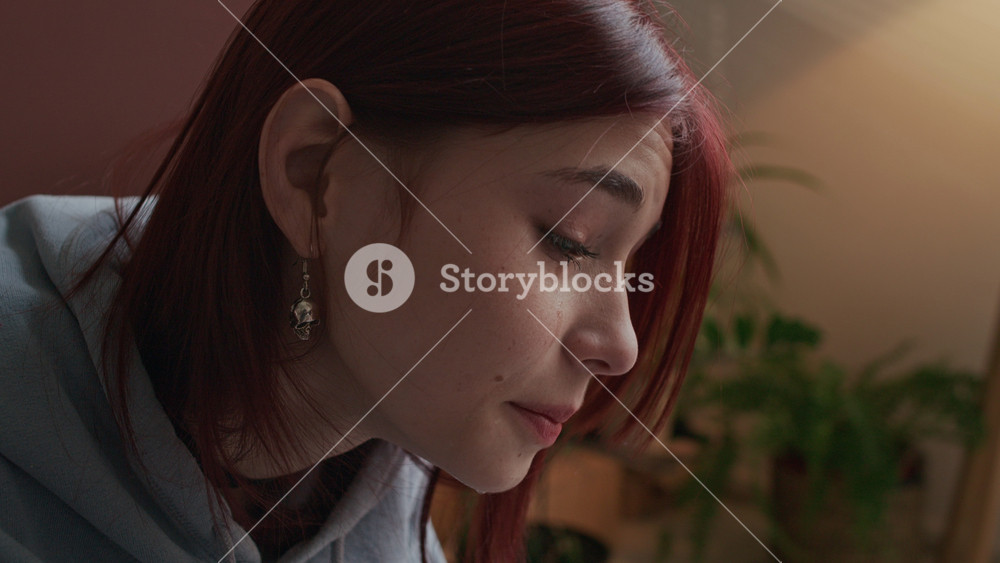 Close-up shot of redhead teenage Caucasian girl crying in pain at therapy session, she wiping away tear rolling down her cheek, going through difficult period