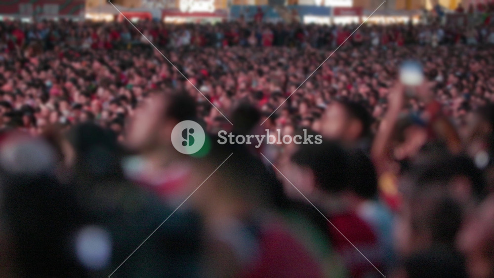 Crowd of enthusiastic football fans in red attire cheering and celebrating during the championship match in Lisbon, with a vibrant