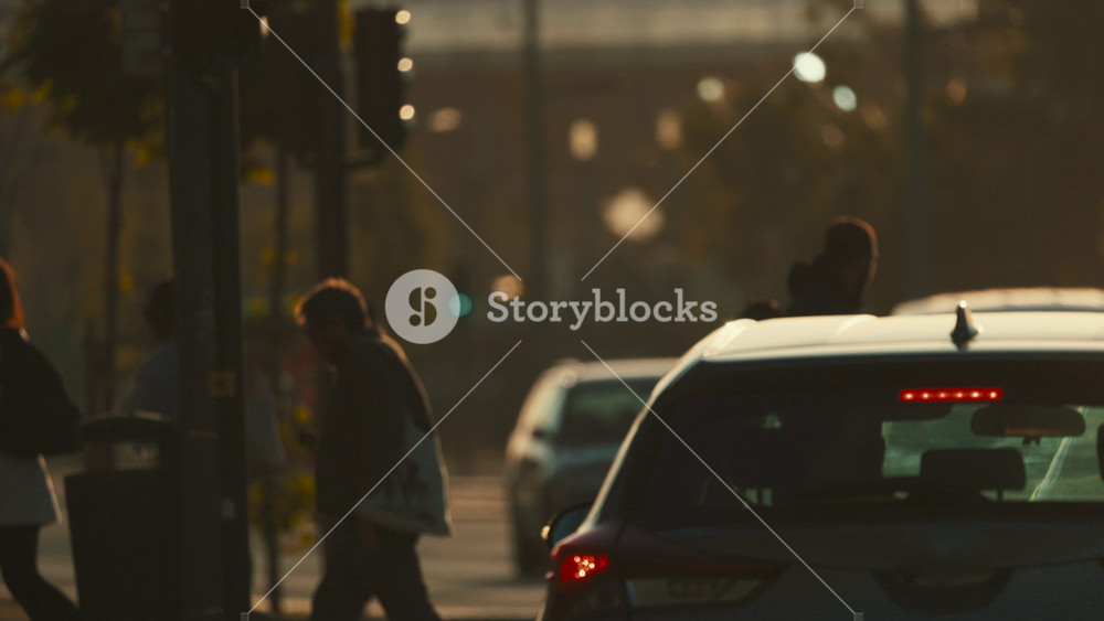 14 may 2026. Lisbon, Portugal - People walk near parked cars in a busy area during late afternoon hours in a city