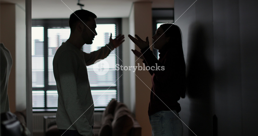 Man and woman shouting at each other, couple quarreling in the evening at home. Husband and wife screaming. Scandal and crisis in family.