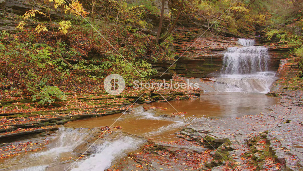 4K footage of Buttermilk Falls State Park, Ithaca NY showcasing the frothy cascade formed by Buttermilk Creek during autumn with vibrant seasonal foliage