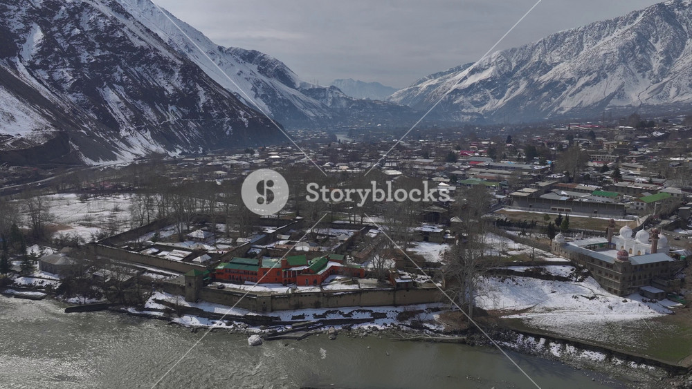 Aerial view in Winter of a historical Fort in Chitral, Pakistan. Bright building along the riverbank in Kalash Valley.