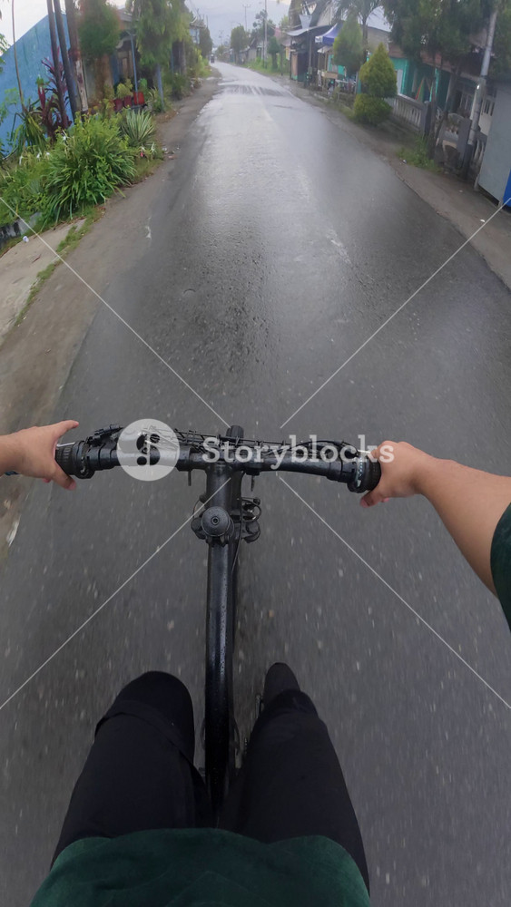 Point of View of Biker Riding in Rain. POV of a cyclist in Gorontalo city in the afternoon and the road conditions are wet due to rain