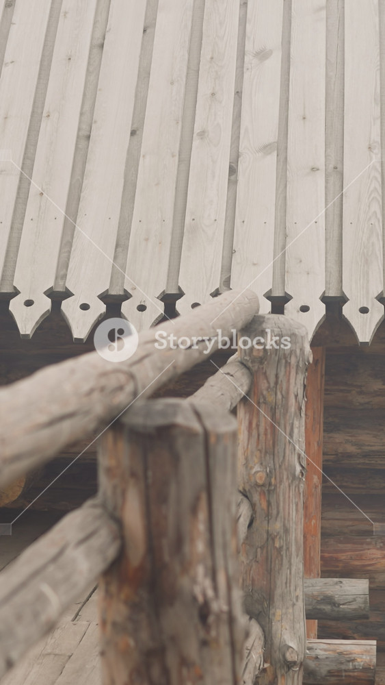 Traditional log house with fence and viewing platform. Wooden building with carved roof for residence of people of Middle Ages. Historical