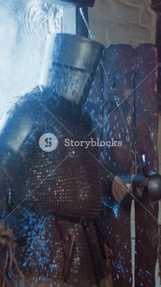 Knight with sword comes in tavern on winter day at snowfall. Strong adventurer in metal armour carries artefacts to merchant store. Warrior