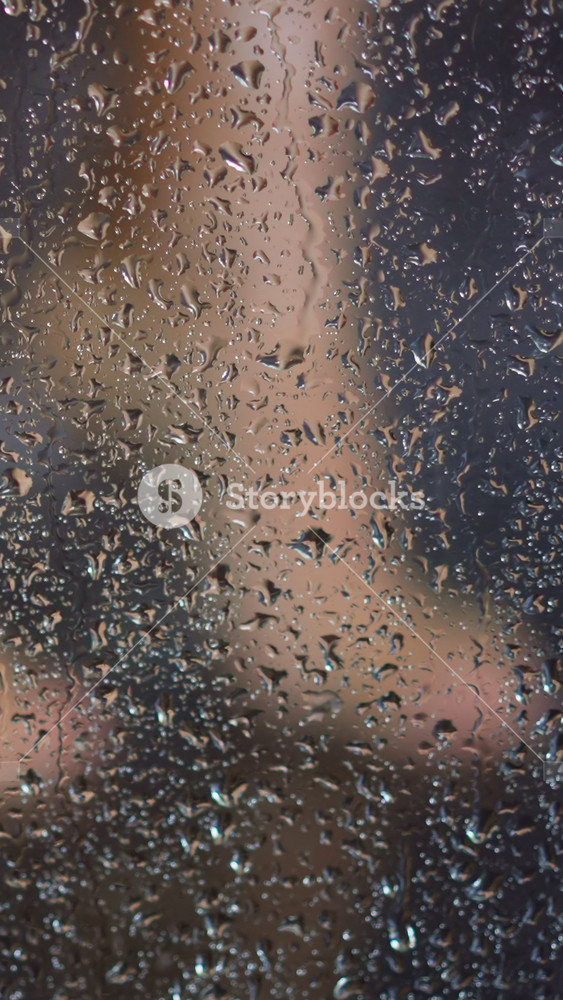 Young woman washes feet in shower behind transparent fogged booth glass with flowing drops of warm water daily routine slow motion closeup