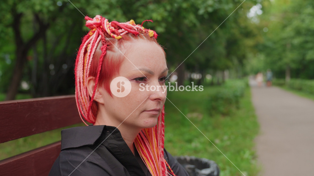 cheerful woman with colorful braids, caucasian woman with cheerful expression and lively braids near trees, woman with expressive gestures