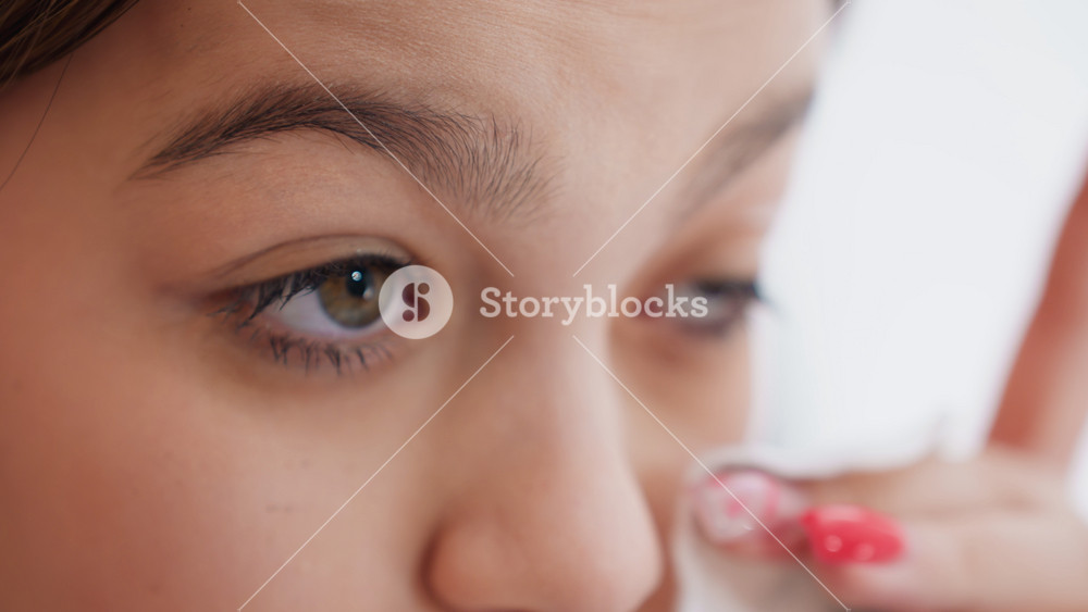 Closeup Of Teen Cleaning Eye Area, Youth Carefully Wiping Delicate Eye With Small Cotton Pad, Teenager Attentively Applying Gentle Strokes