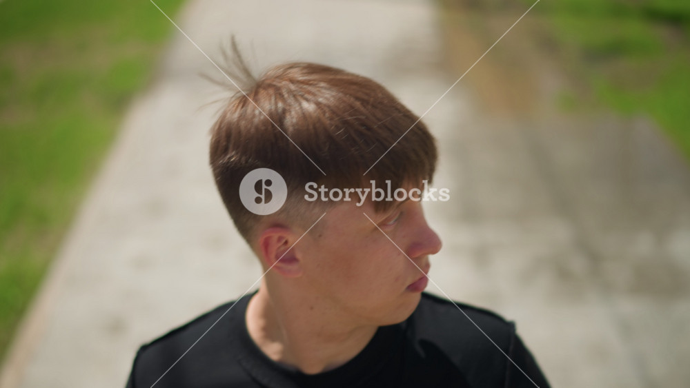 caucasian male pauses outdoors briefly, youthful man pauses attentively amidst ongoing outdoor engagement, young caucasian male momentarily