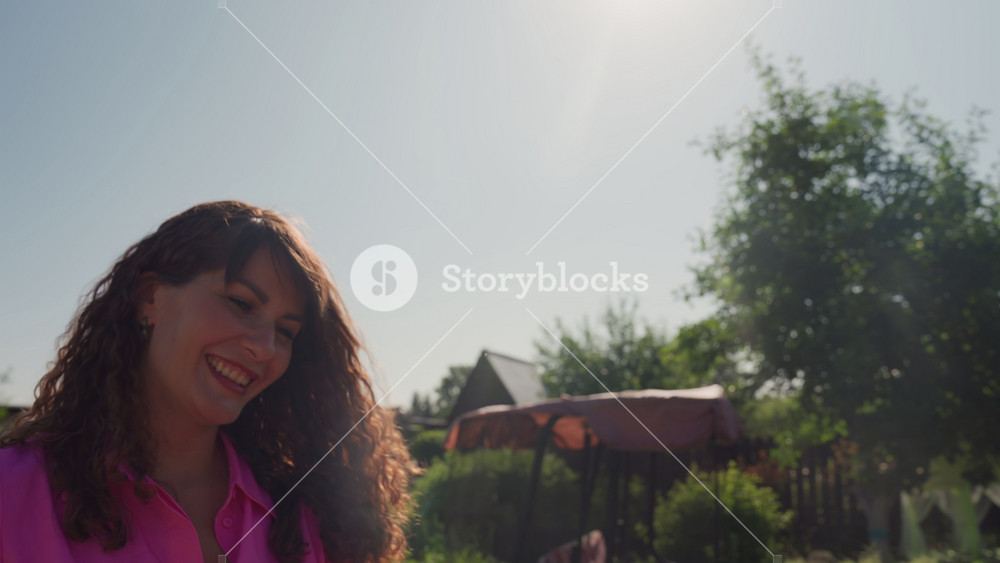 Caucasian Lady With Curly Hair Smiling Outdoors, Relaxed Woman Enjoying Sunshine With Cheerful Expression In Garden, Woman With Curly Hair