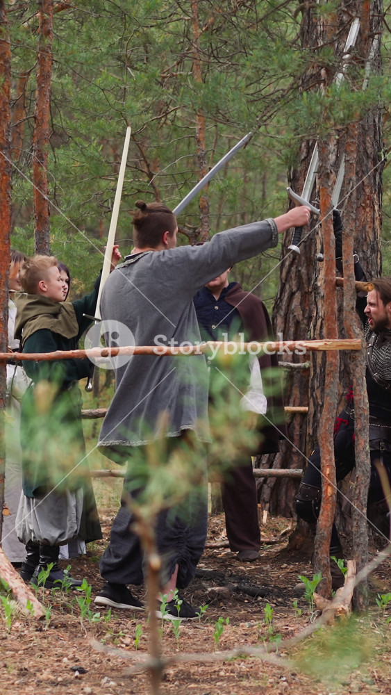 Brave warriors raise up swords at training in fir wood slow motion. Historical events reconstruction club. Battle with old armour to have