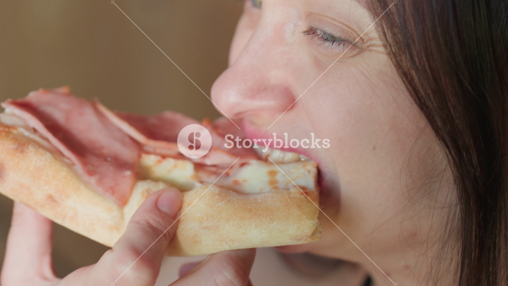 Close up of woman enjoying a slice of grilled chicken pizza, with melted cheese and tender chicken pieces, capturing the satisfaction of