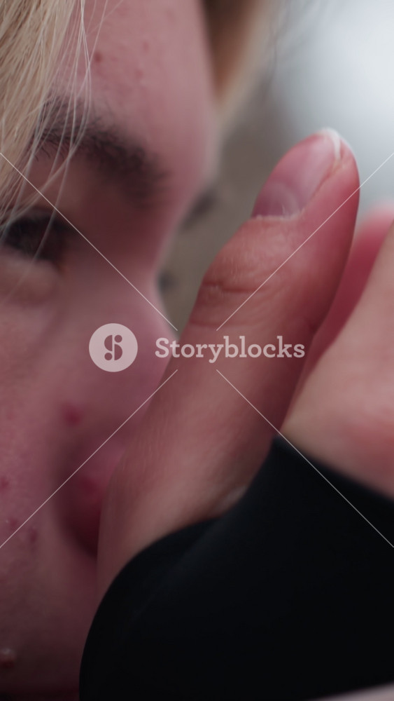 Close-up face view of woman feeling cold in winter, rubbing hands for warmth, red nose and chapped skin show harsh weather conditions