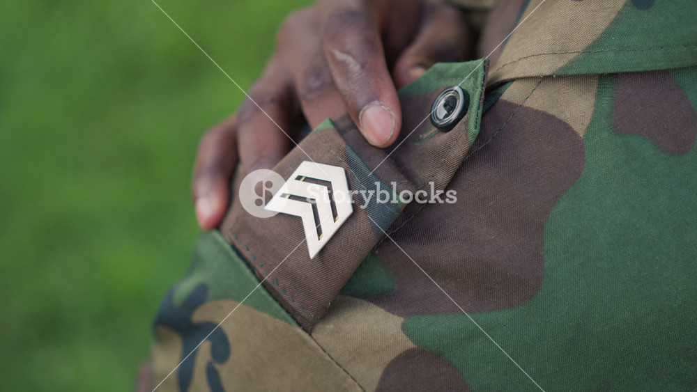 Soldier Examines Badge Closely, Military Officer Carefully Inspects Shoulder Badge, Service Member Conducts Detailed Inspection Of Shoulder