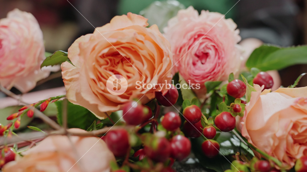 Floral display details. Closeup of flowers and berries. Intricate arrangement with vibrant roses and berries. Artisan styled floral