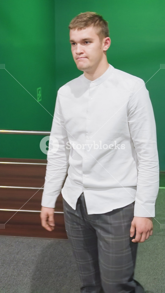 Front shot of male in shirt and trousers walking up stairs, moving into billiard room. Green lighting casts a unique glow on surroundings